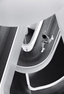 Un athlète (JO Tokyo 2020) court dans un décor moderne et symétrique. Photographie de sport pour le projet FUSION sport et architecture. Des photographies sportives pour révéler l'émotion et la beauté du geste.