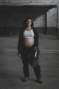 Portrait d'une femme enceinte dans son atelier de soudure. Du naturel à la mise en scène : des portraits adaptés à votre univers.